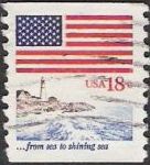 18-cent U.S. postage stamp picturing American flag over lighthouse and coastline
