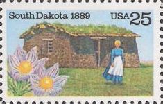 25-cent U.S. postage stamp picturing woman and flowers in front of cabin